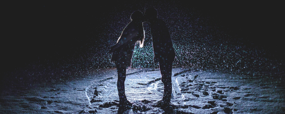 Küssendes Paar im Schnee in der Nacht